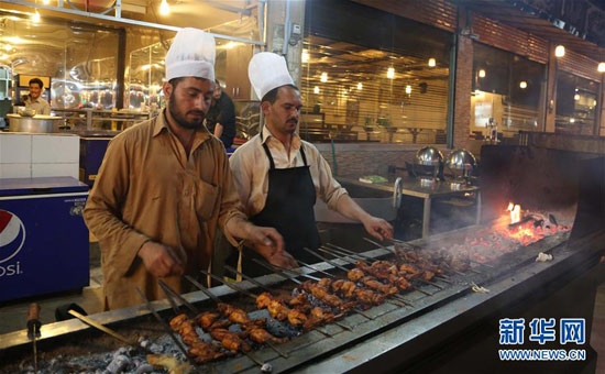 巴基斯坦拉瓦爾品第的一條美食街上，廚師在烤制雞肉串和羊肉串。