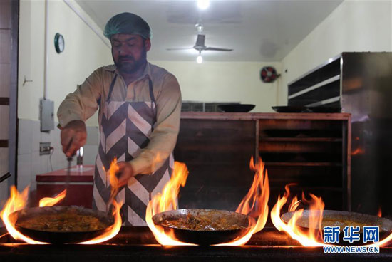 巴基斯坦拉瓦爾品第的一條美食街上，廚師在烤制雞肉串和羊肉串。