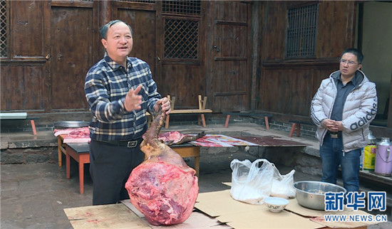 楊伍松在演示火腿制作技藝。