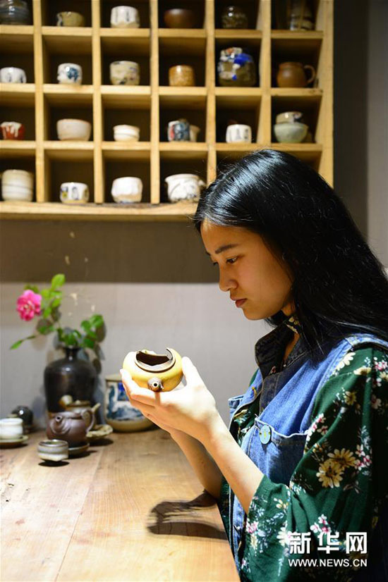 黃俊玲在查看一把破損的茶壺。