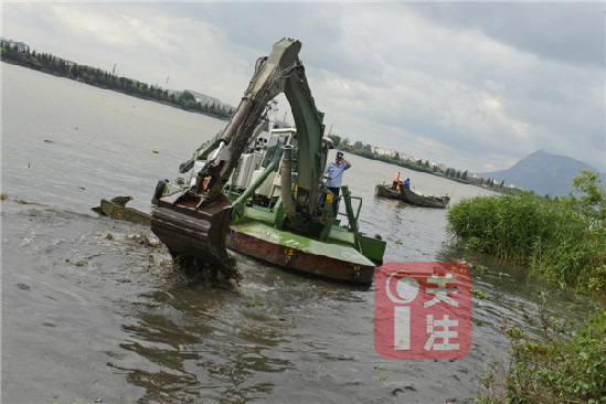水上挖機(jī)對私搭亂建的釣魚平臺和殘留木樁進(jìn)行拆除和取締