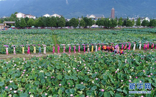 旗袍愛好者在四川省綿竹市九龍鎮(zhèn)新龍村荷塘參加旗袍走秀