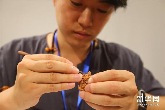 9月25日，藝人在展覽現(xiàn)場制作核雕。