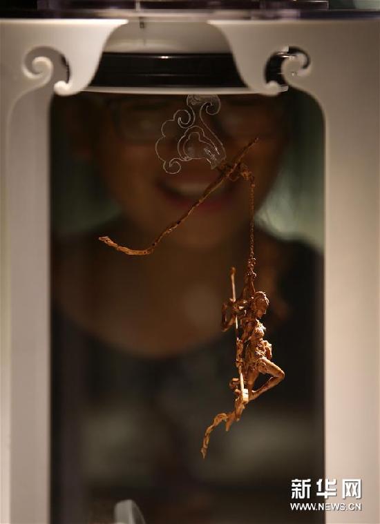 觀眾在展覽上觀看核雕作品《破曉》。