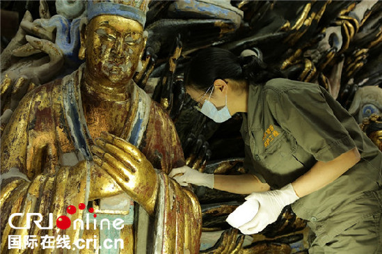 陳卉麗正在修復(fù)大足石刻千手觀音造像。陳卉麗供圖