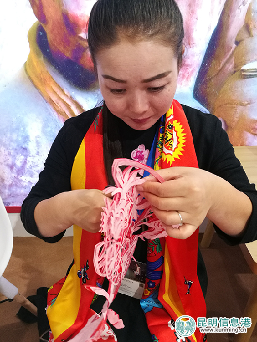 陜西靖邊展區(qū)的剪紙師傅正在剪紙。
