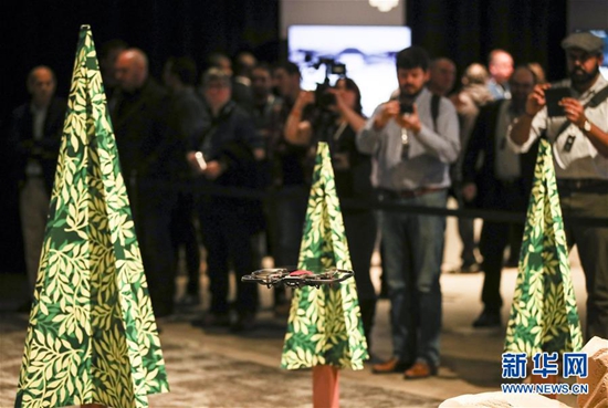 在美國紐約，觀眾在發(fā)布會上觀看大疆新款無人機Mavic Air繞開障礙物功能演示。