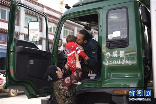 出發(fā)前，澤仁曲西將孫子舉到丈夫其美多吉跟前，讓祖孫倆告別（2017年8月28日）。新華社記者 吳光于 攝