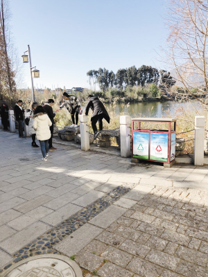 游客翻越民族村內(nèi)護(hù)欄照相。