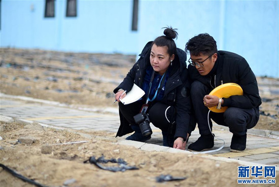  索朗央吉（左）與村干部測(cè)量房前屋后的地，準(zhǔn)備種植玫瑰、牧草等（3月6日攝）。新華社記者 覺果 攝