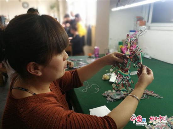 郭女士展示綴結(jié)好的皮影（王偲瑤 攝）