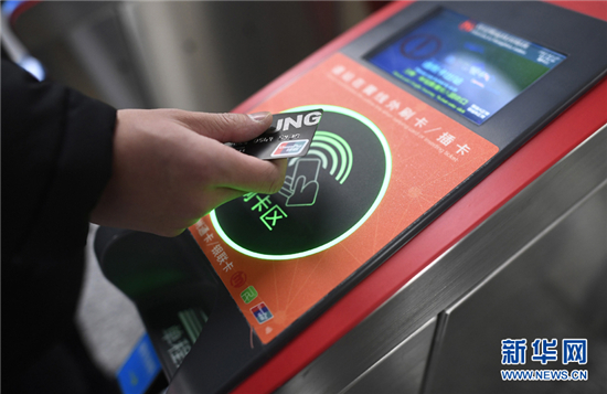 乘客在杭州地鐵豐潭路站體驗使用帶有閃付功能的銀聯(lián)IC卡過閘乘車(2017年12月27日攝)。新華社記者 黃宗治 攝