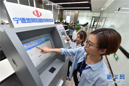 寧德時代新能源科技有限公司的員工在辦稅員的指導(dǎo)下試用自助辦稅終端(2017年10月12日攝)。新華社記者 宋為偉 攝