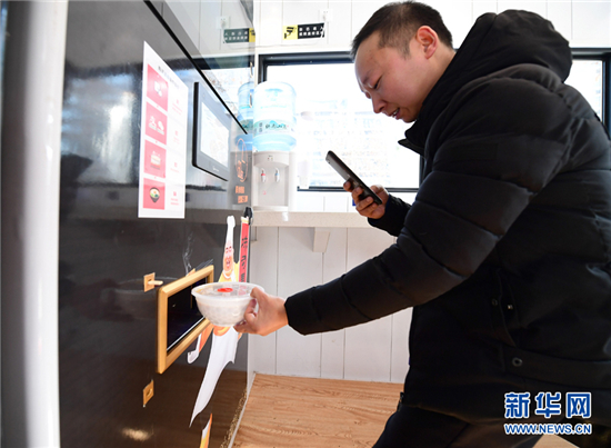 　在位于西安曲江創(chuàng)客大街邊的一家無人面館內(nèi)，市民用手機拍攝機器剛做好的面食（1月10日攝）。新華社記者 邵瑞 攝