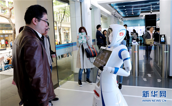     一位市民在位于上海九江路的無人銀行入口處向迎賓機器人說明需要辦理的業(yè)務(wù)種類(4月12日攝)。近日,中國建設(shè)銀行在上海九江路開出國內(nèi)首家無人銀行。新華社記者 方喆 攝
