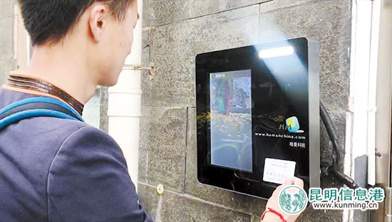     小區(qū)工作人員演示“刷臉卡”進門。