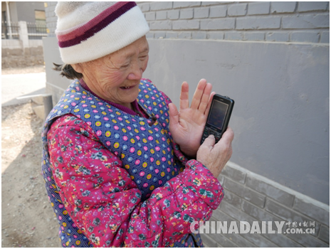 村民聞老太向記者展示手機里自己拍攝的花展照片 李雪晴/攝 村民聞老太向記者展示手機里自己拍攝的花展照片 李雪晴/攝