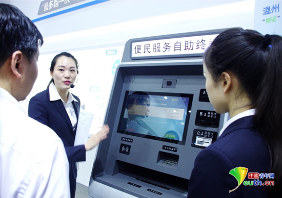 首屆數(shù)字中國(guó)建設(shè)成果展覽會(huì)上，在電子政務(wù)展區(qū)浙江展臺(tái)前，工作人員正在向觀眾講解便民服務(wù)自助終端的使用方法。10類101個(gè)服務(wù)事項(xiàng)可以通過這臺(tái)機(jī)器來辦理。中國(guó)青年網(wǎng)記者 張潼 攝