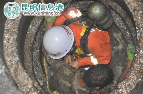 救援官兵用力向上拉出被困人員和下井的救援官兵