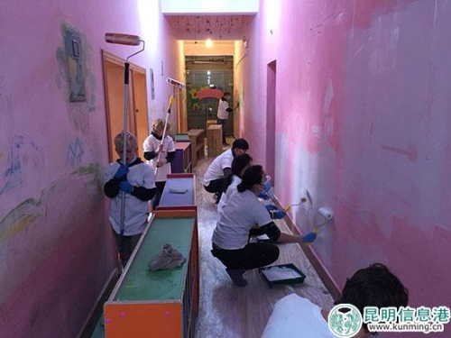 志愿者正在把福利院的墻刷成粉色。供圖