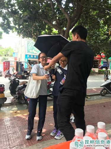 活動現(xiàn)場，工作人員為考生及家長送水