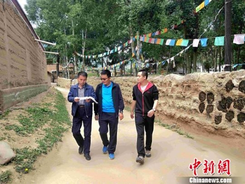 圖為“第一書記”和駐村干部在村里走訪?！±铍h 攝
