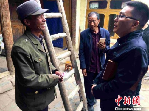 圖為“第一書記”楊同業(yè)慰問貧困戶。　李雋 攝