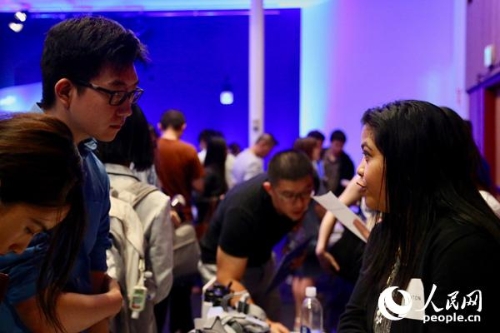 在領(lǐng)英海外人才招聘活動(dòng)上，一名求職者（左）與企業(yè)代表進(jìn)行交流。人民網(wǎng)張潔嫻攝