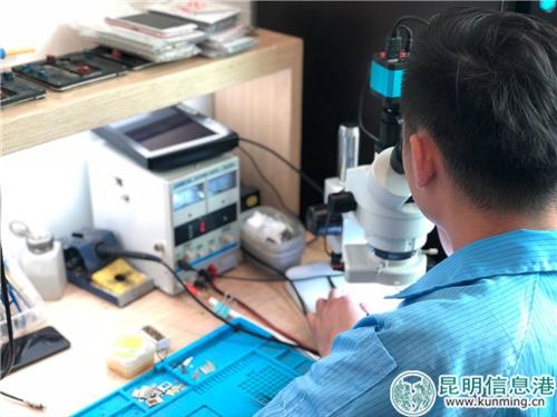 世紀城店手機維修工程師在進行手機芯片檢查。記者馬文燾攝