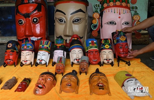 方文展在家里整理自己的毛南族儺面作品