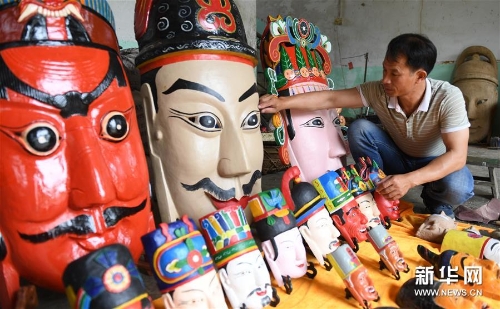 方文展在整理自己制作的毛南族儺面作品