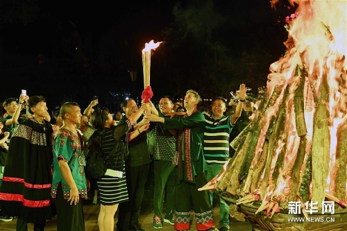 游客在云南楚雄彝人古鎮(zhèn)點(diǎn)燃火把