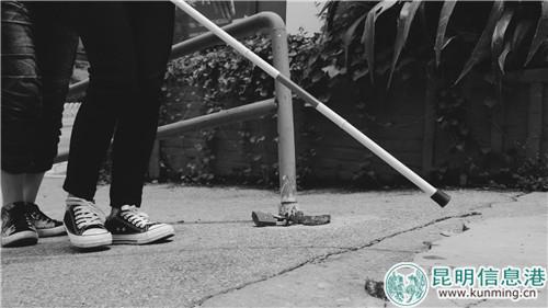 志愿者手持盲杖體驗兩點式探路法。