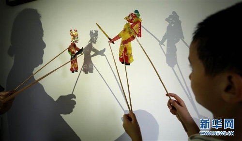 8月14日，李衛(wèi)與外孫一起表演皮影戲。