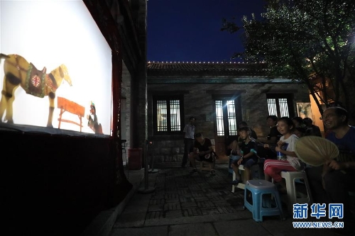 李衛(wèi)在濟南百花洲為市民表演皮影戲（7月15日攝）。