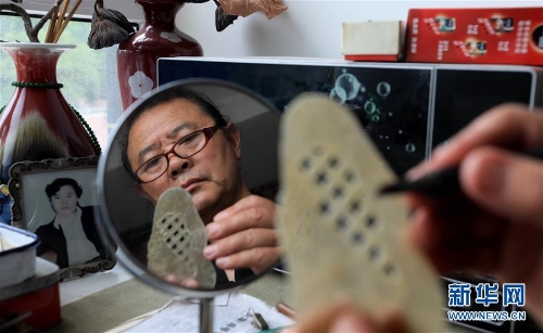 李衛(wèi)在家中雕刻皮影人偶配件（7月11日攝）。