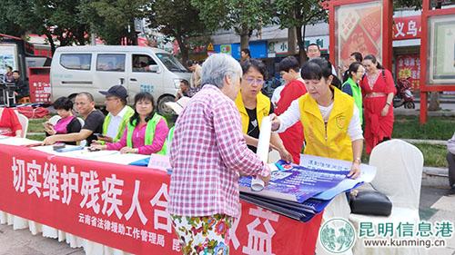 盤龍區(qū)法律援助中心工作人員向市民發(fā)放宣傳單。實習(xí)記者劉璐璐攝