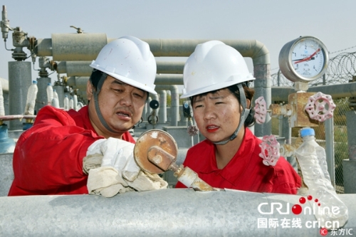 圖片默認(rèn)標(biāo)題_fororder_（10月1日國慶佳節(jié)，新疆輪臺(tái)地處塔里木河北岸的中國石化西北油田阿探集氣站上，師傅許鵬和徒弟何變雄在工作崗位上。東方IC版權(quán)圖片）