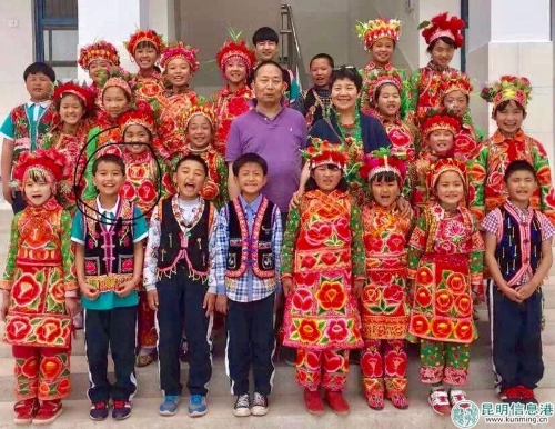 周林夫婦在巍山縣鳳山春苗小學(xué)教學(xué)樓前與彝族孩子們合影。