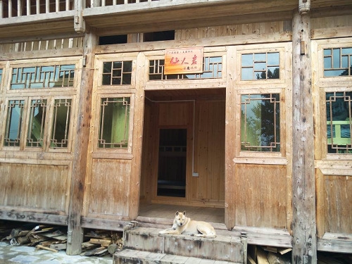 八舟河邊的民宿，一只小狗臥在門前曬著太陽(yáng)，打著瞌睡。