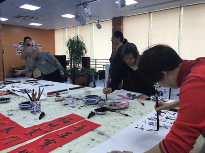 老人們?cè)谑忻耋A站活動(dòng)室里揮毫潑墨。（孔華/攝）