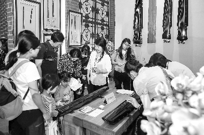 觀眾在非遺展區(qū)體驗古琴彈奏    陳德歡 攝