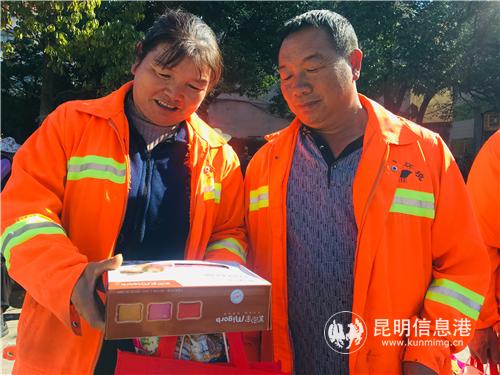 圖2：呈貢區(qū)環(huán)衛(wèi)工人高興地查看收到的禮品。
