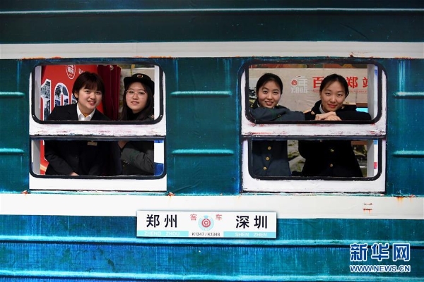 體驗者穿著不同時期的鐵路職工工作服在“綠皮車”造型展板前留影