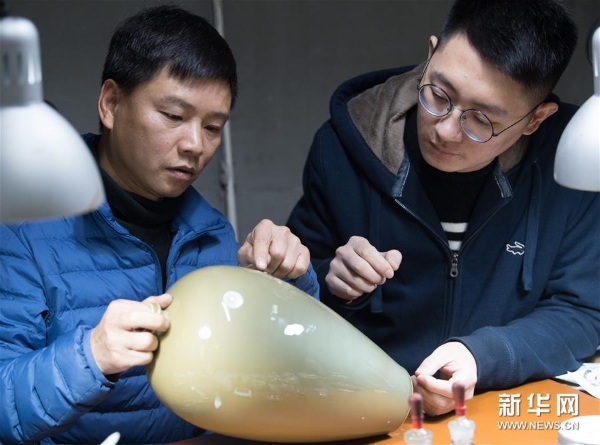 龍泉青瓷藝術(shù)家楊盛侃（右）將一件有瑕疵的作品帶到吳榮強的工作室，跟他討論漆繕修復(fù)的細節(jié)。