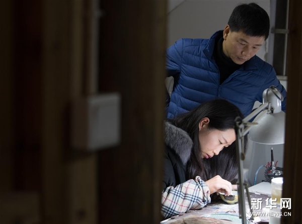 吳榮強和妻子李淑敏在龍泉市牛頭嶺村“七分醉”工作室對一件漆繕器皿進行打磨