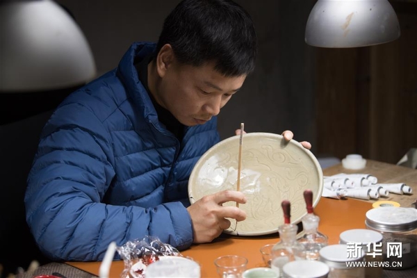 吳榮強在龍泉市牛頭嶺村“七分醉”工作室對一件青瓷器皿進行漆繕