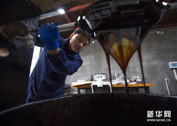 吳榮強在龍泉市牛頭嶺村“七分醉”工作室濾漆