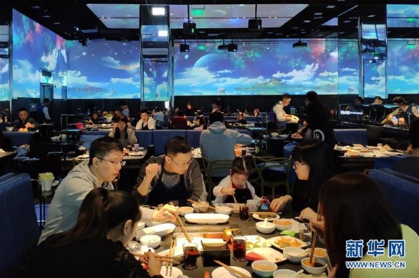 在北京海底撈智慧餐廳，食客們?cè)诼暪獬两江h(huán)境中享用火鍋（1月30日手機(jī)拍攝）。