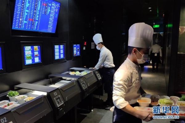 在北京海底撈智慧餐廳，員工在后廚工作（1月30日手機(jī)拍攝）。